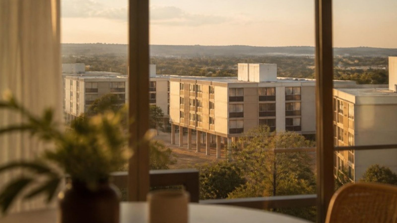 Vista de janela de apartamento para prédios residenciais de Brasília ao entardecer