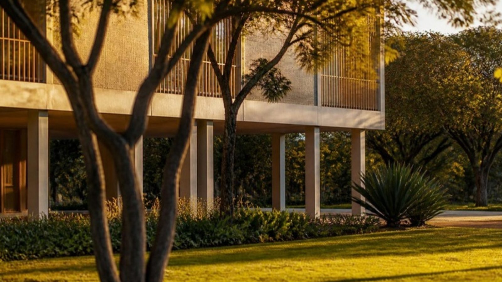 Edifício residencial modernista sobre pilotis em Brasília, com jardim e árvores do cerrado ao entardecer