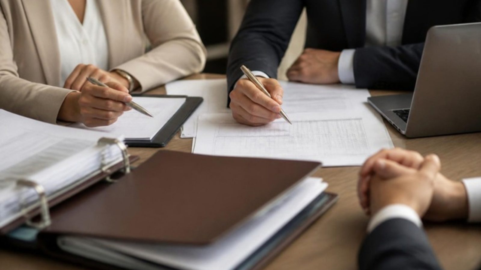 Sócios e contador analisam balanço e documentos fiscais em reunião